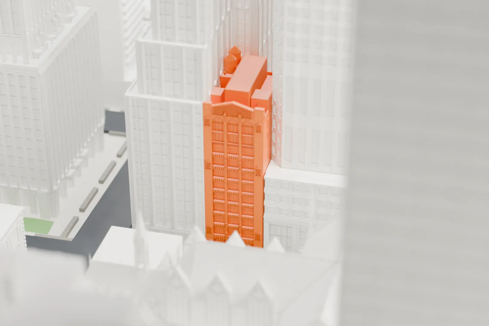 A white 3D print of 18 East 50th Street among tall gray buildings with gridded facades.