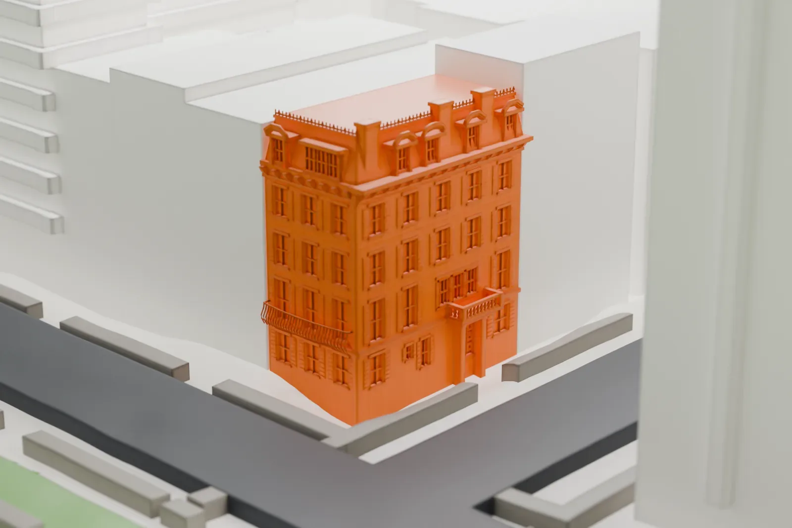 A white 3D print of 19 Gramercy Park South, a house with a mansard roof and ornate dormers, wedged between larger buildings beside a green park.