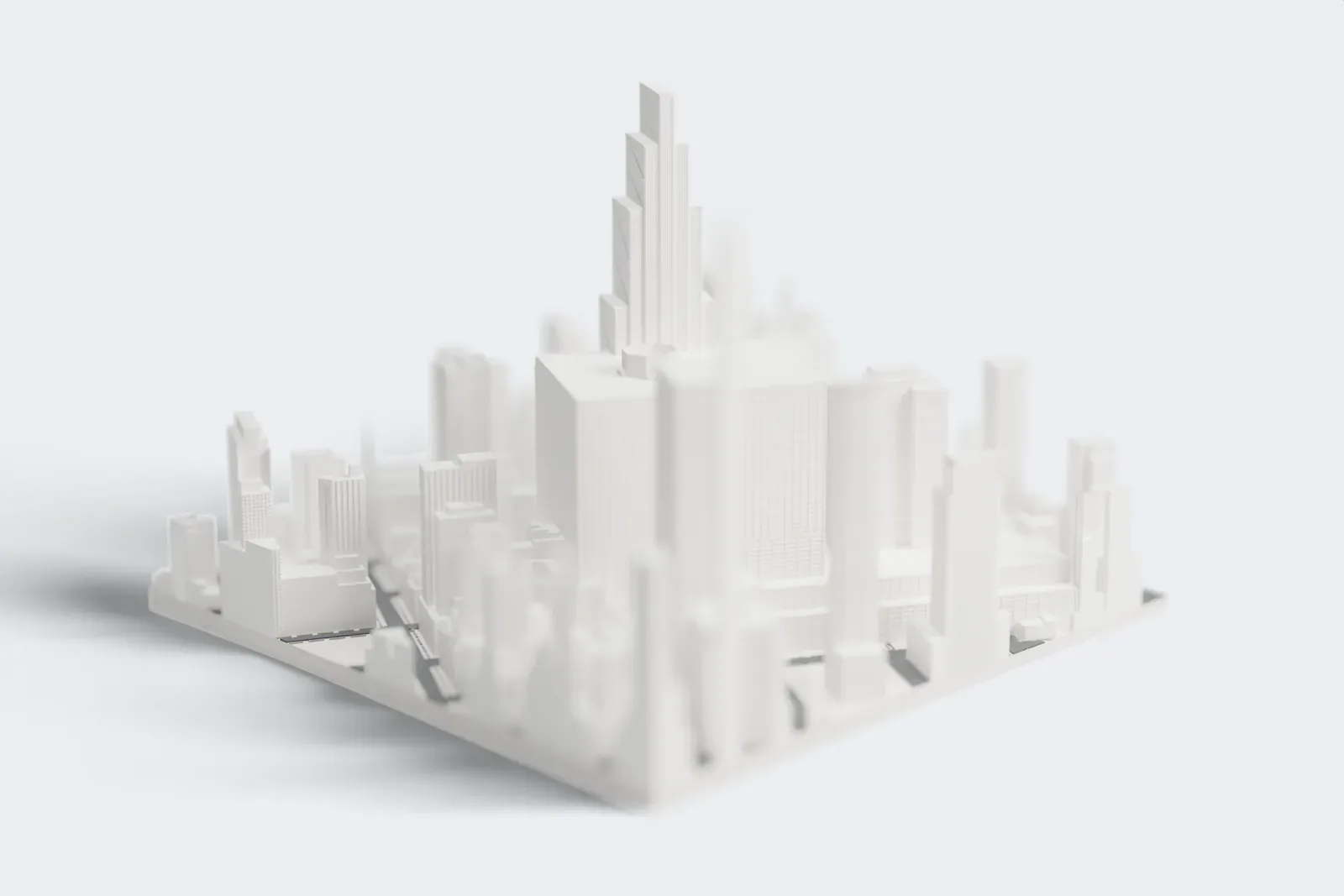 A white 3D print of 270 Park Avenue, a tall stepped skyscraper, rising among the dense buildings of Midtown Manhattan.