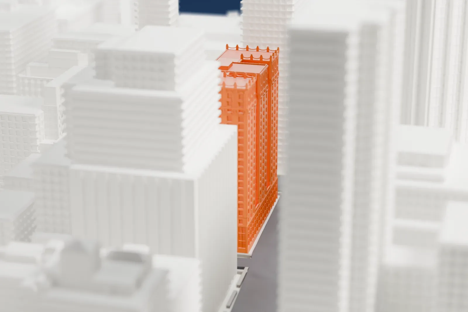 A white 3D print of 4 Park Avenue, a tall building with an ornate crown, among taller and lower Midtown buildings.