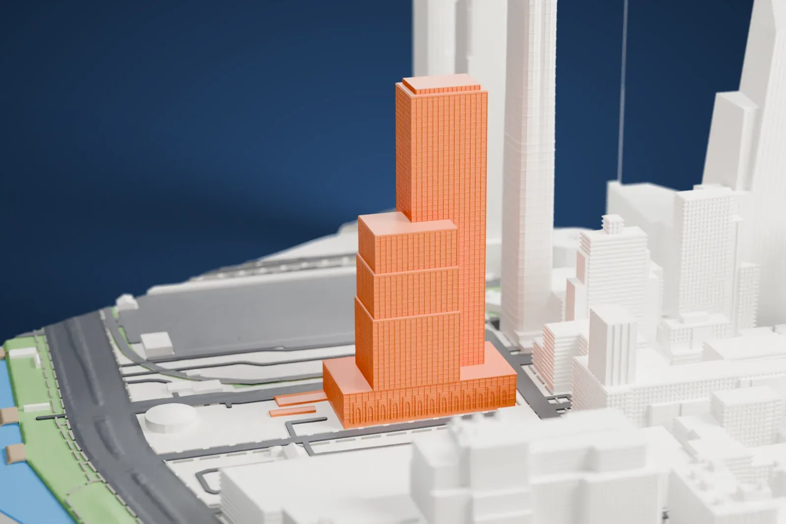A white 3D print of 601 West 29th Street, a tall tower beside a stepped lower wing on a wide base, near taller neighboring towers and open ground.