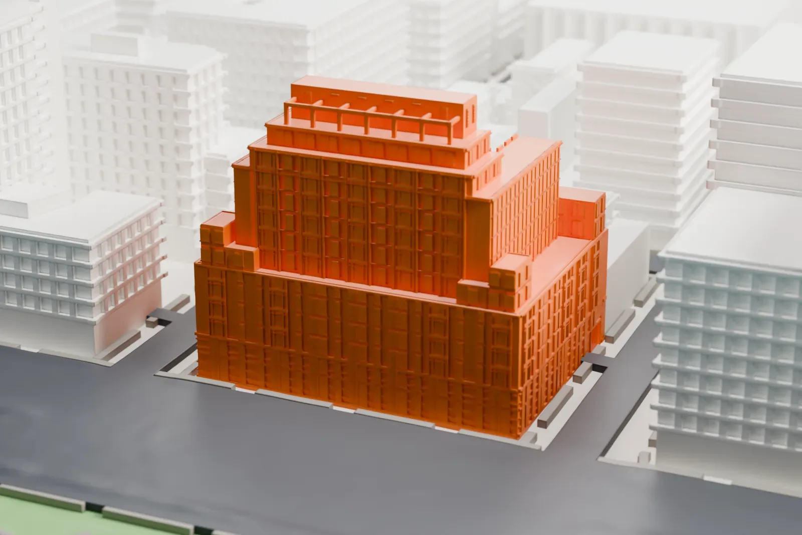 A white 3D print of 70 Vestry, a stepped residential block among nearby buildings and streets, with water and green space behind it.