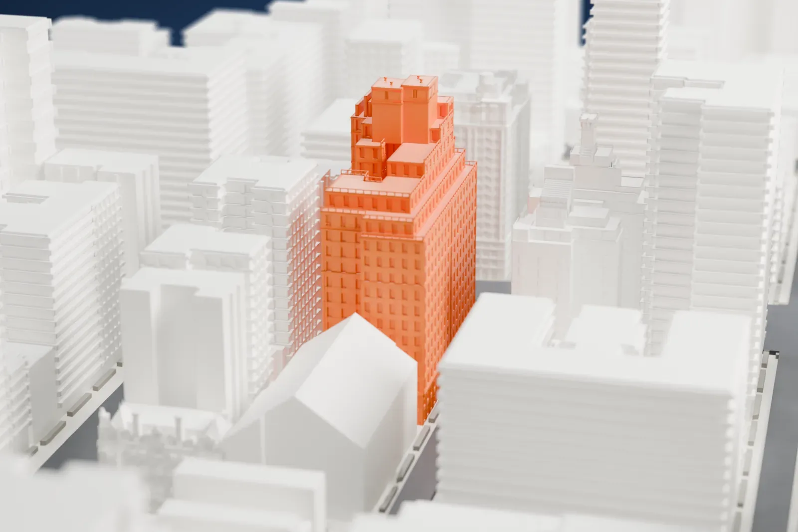 A white 3D print of 740 Park Avenue, a tall stepped apartment building with small towers on top, packed in among other buildings.