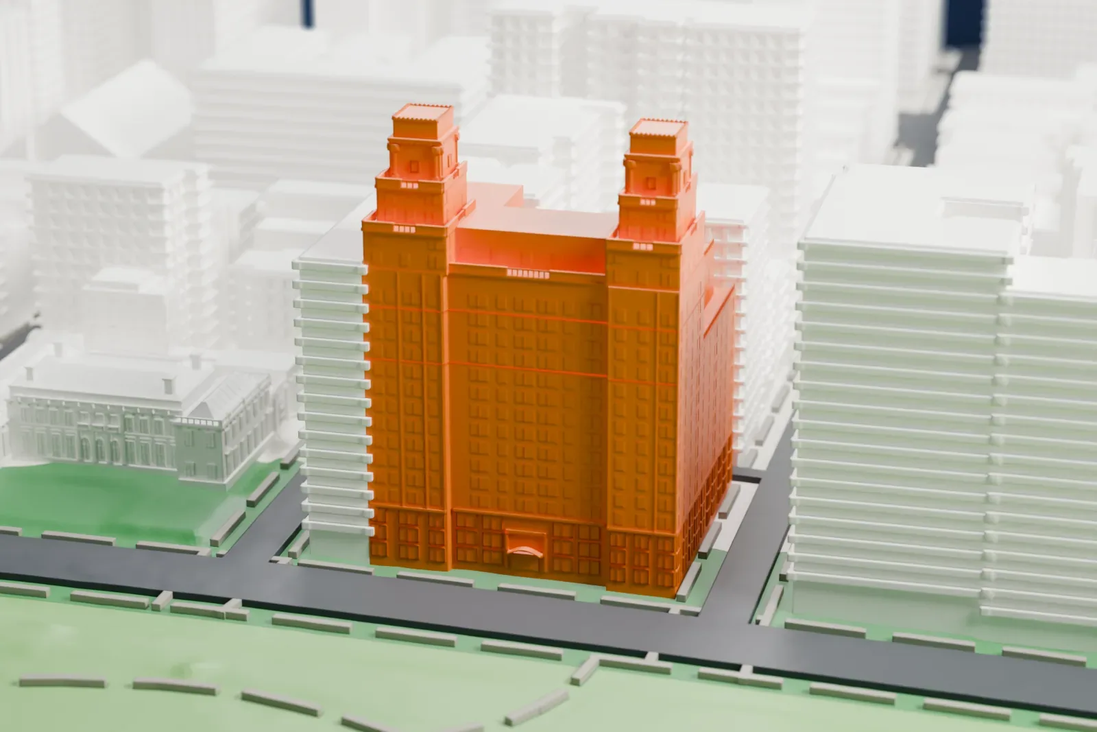 A white 3D print of 880 Fifth Avenue, a tall apartment building with a pair of small towers on top, beside green parkland and neighboring buildings.