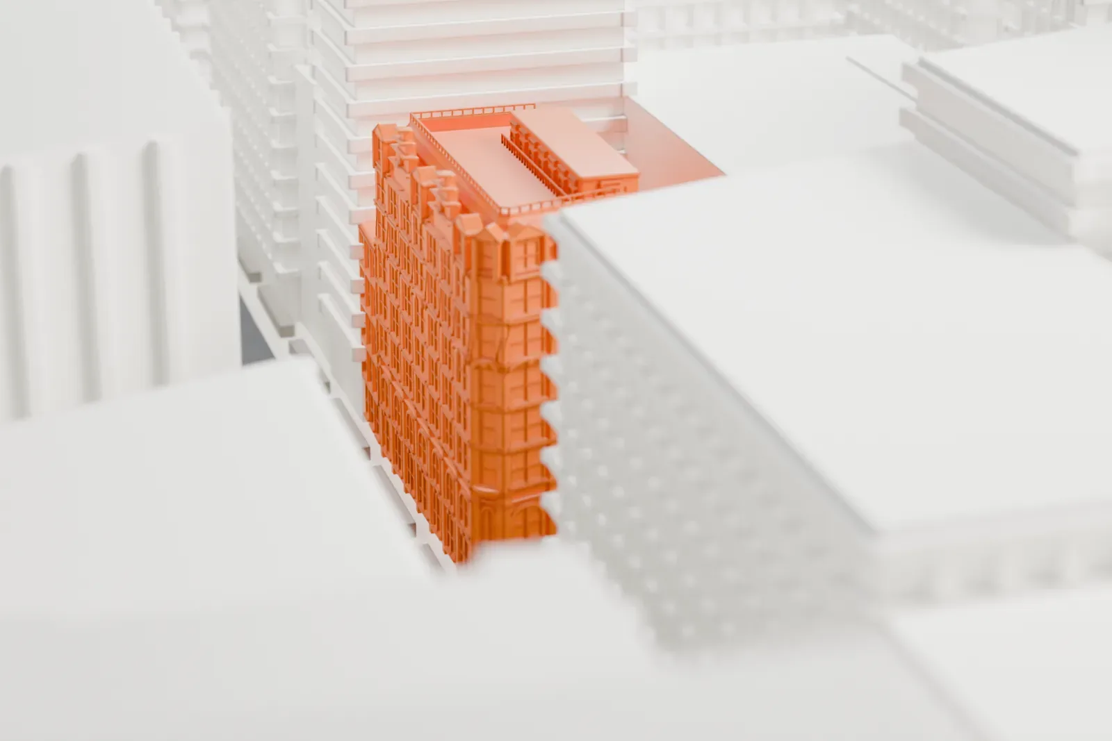 A white 3D print of 889 Broadway, a tall brick building with an ornate facade and a steep roof with dormers, set deep among larger, plainer buildings.