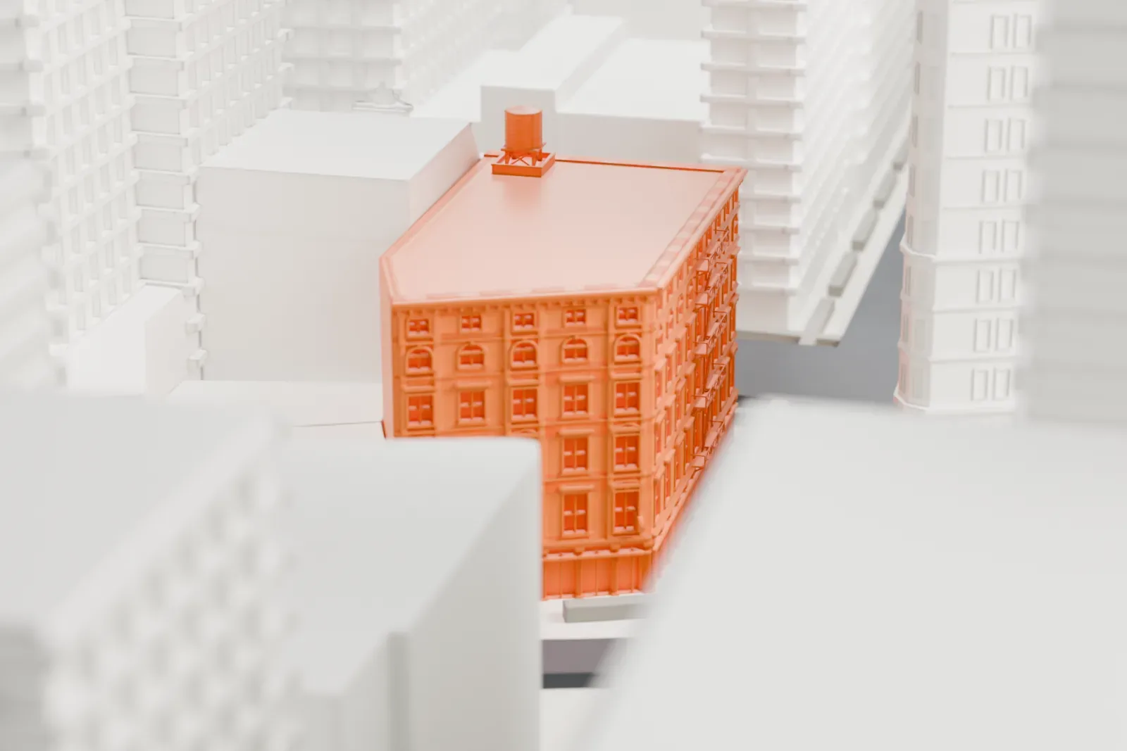 A white 3D print of 935-939 Broadway, a small building with a detailed facade and a rooftop water tank, standing among much taller buildings.