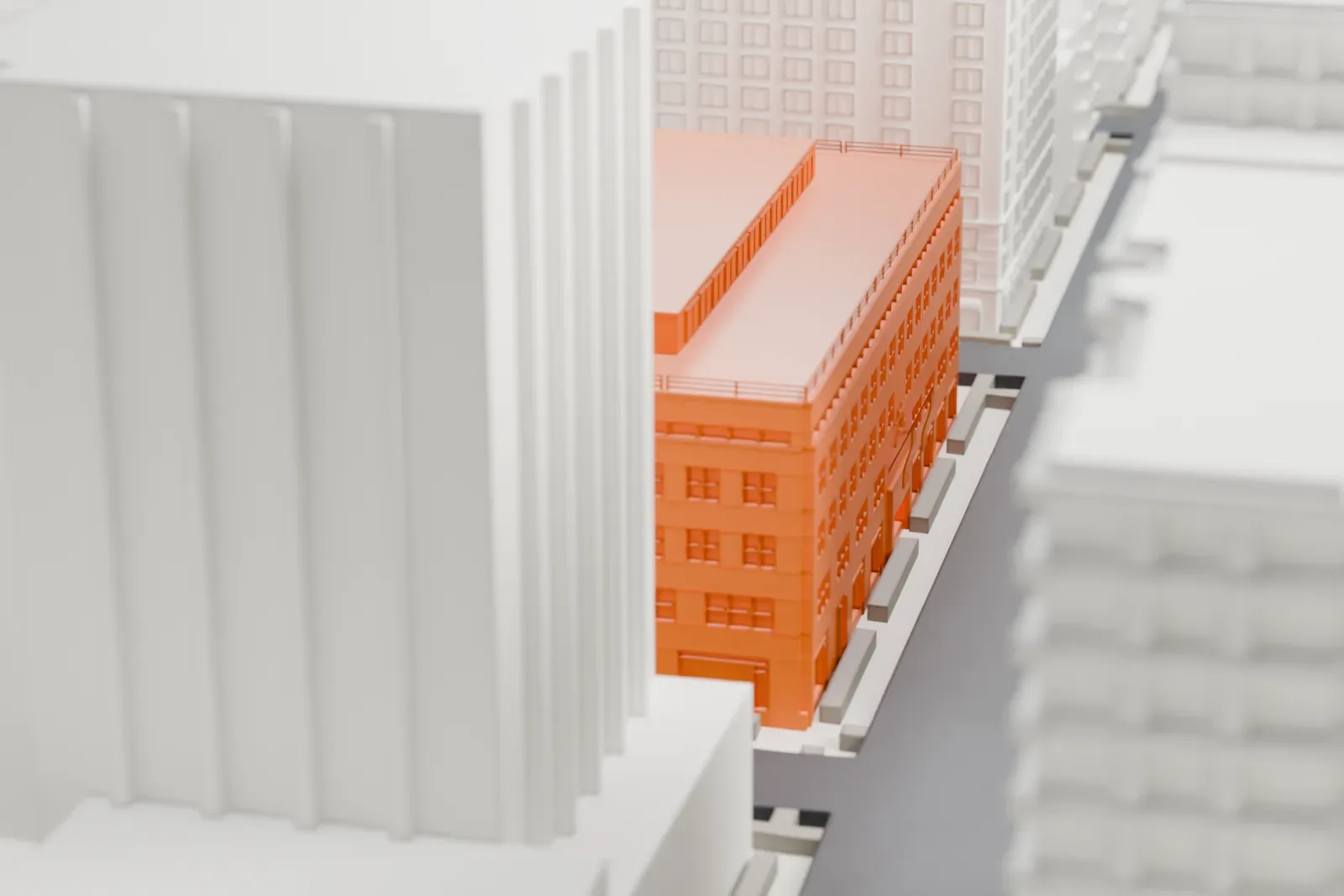A white 3D print of 980 Madison Avenue, a low flat-roofed block surrounded by much taller buildings on city streets.