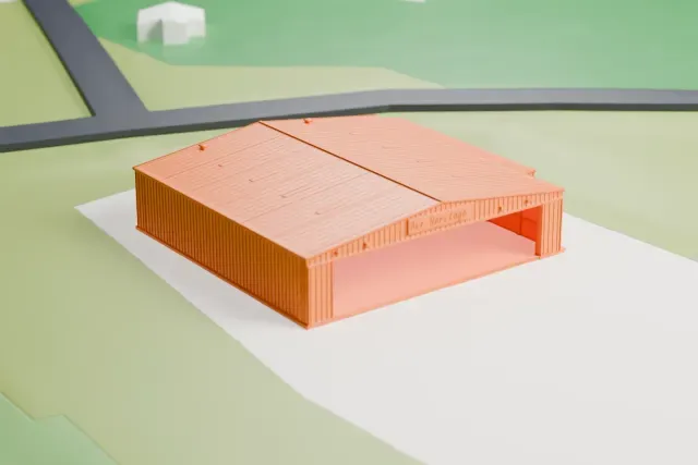 A white 3D print of the Air Heritage Aviation Museum Hangar model in Pittsburgh, with the streets around it.