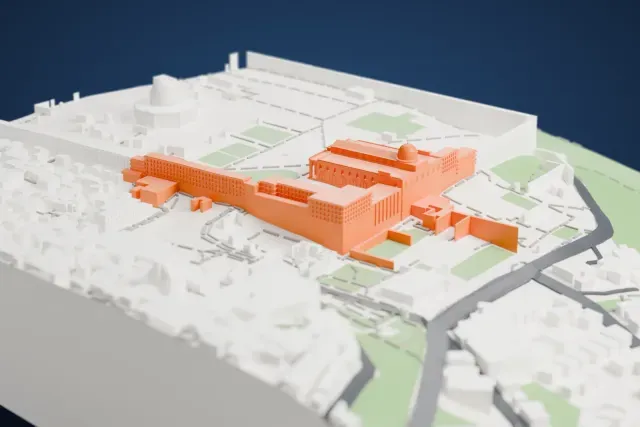 A white 3D print of the Al-Aqsa Mosque, a long rectangular prayer hall with a ribbed central roof and a domed section, surrounded by pale city blocks and open courtyards.