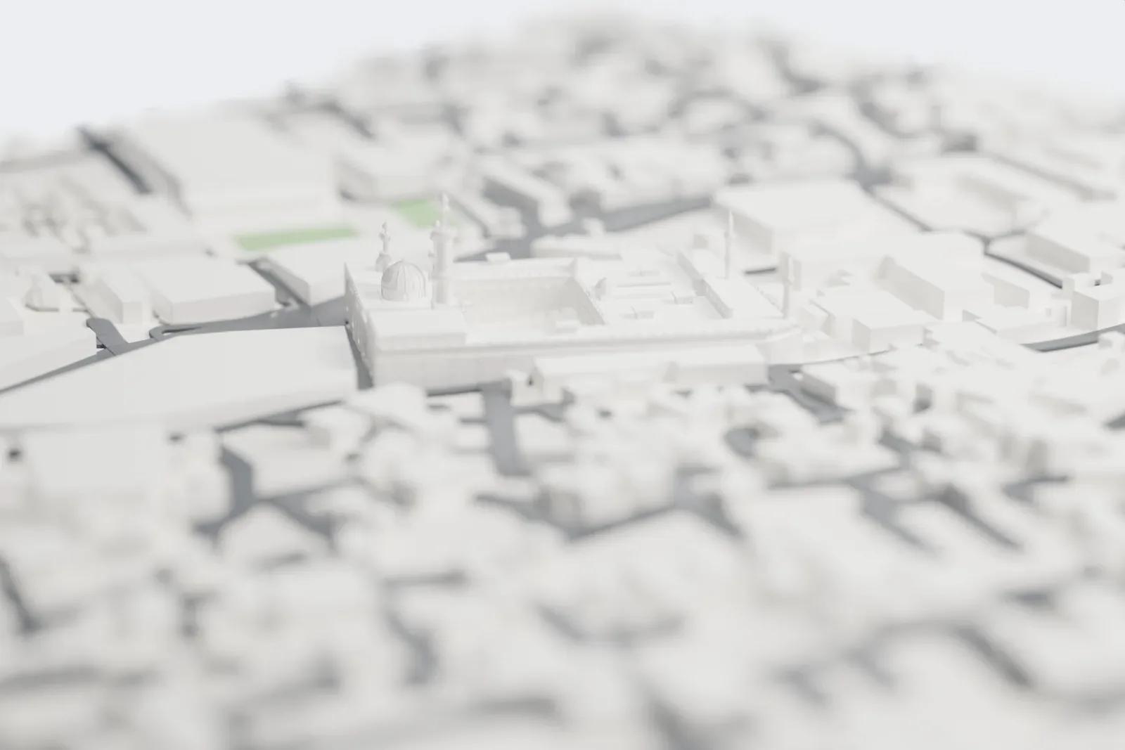 A white 3D print of Al-Azhar Mosque, a large courtyard building with an arcade, several domes and slender minarets, standing among dense city blocks.