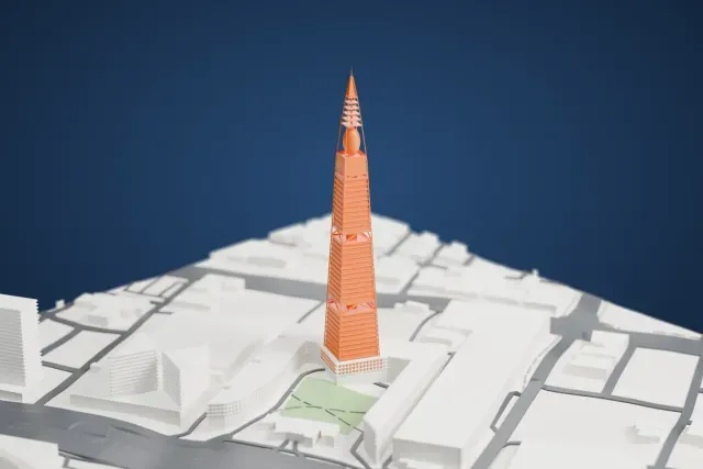 A white 3D print of Al Faisaliah Tower, a tapering tower with a sphere near its top and an open-frame spire, rising from a low building around a small green courtyard, with roads nearby.
