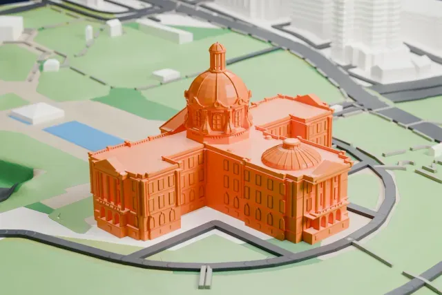 A white 3D print of the Alberta Legislature Building, a symmetrical domed building on green lawns with curving roads and a small pool.