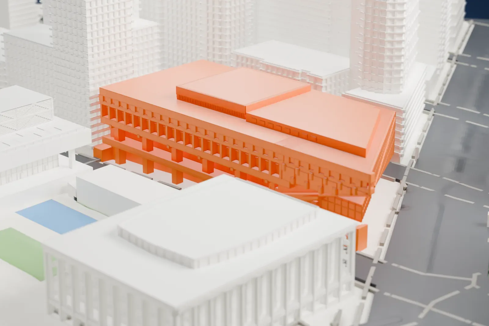 A white 3D print of Alice Tully Hall, a wide, low concert hall with an overhanging wing, between a wide avenue and neighboring buildings.