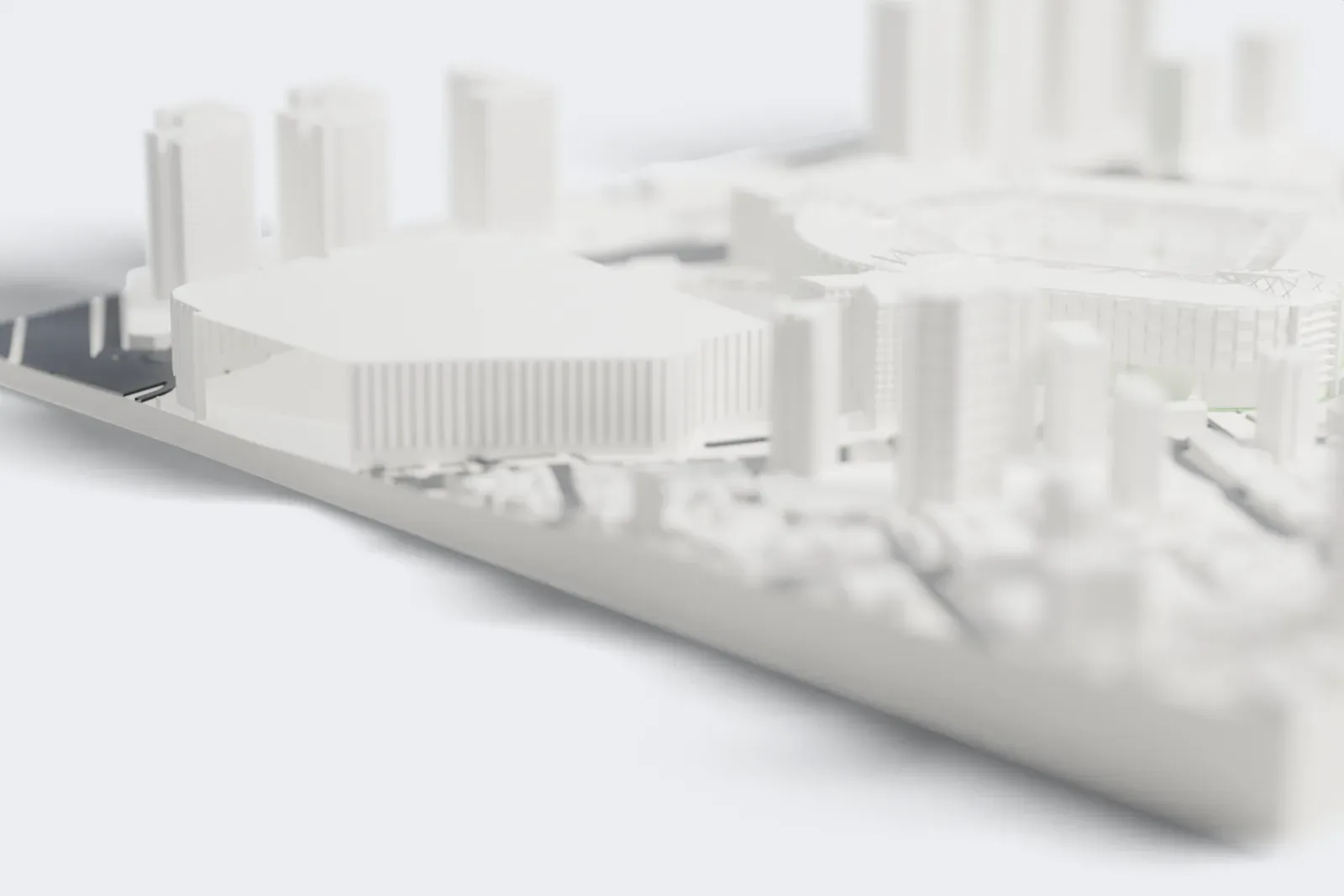 A white 3D print of Allianz Parque, a rounded-square football stadium with a patterned facade and a web of roof trusses around an open bowl, among tall buildings, roads and small green patches.