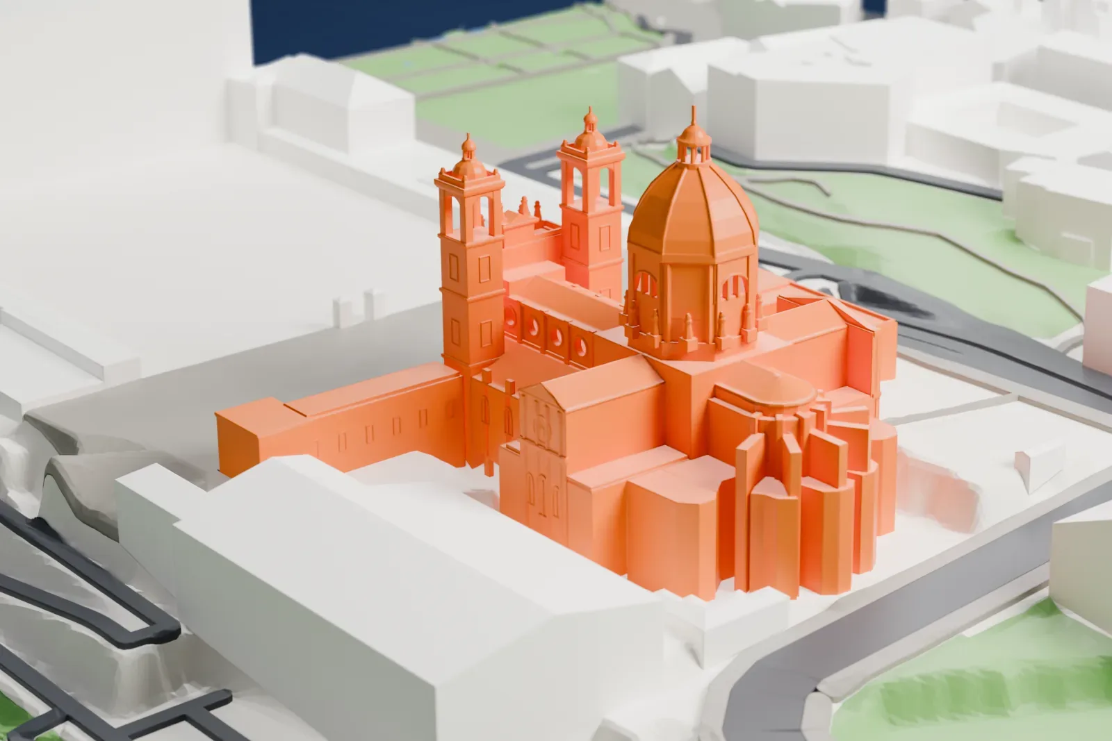 A white 3D print of Almudena Cathedral, a long church with a tall front, standing among the surrounding city streets and buildings.