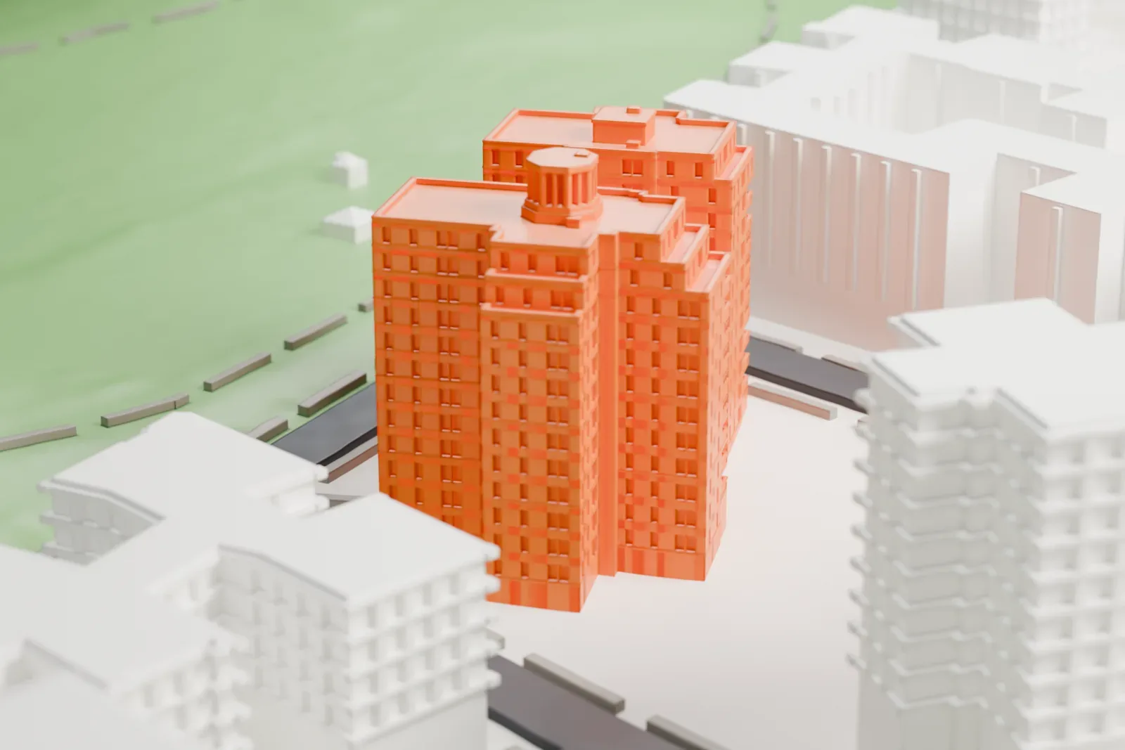 A white 3D print of the Amalgamated Housing Cooperative, two tall blocks joined together, beside a large park and streets.