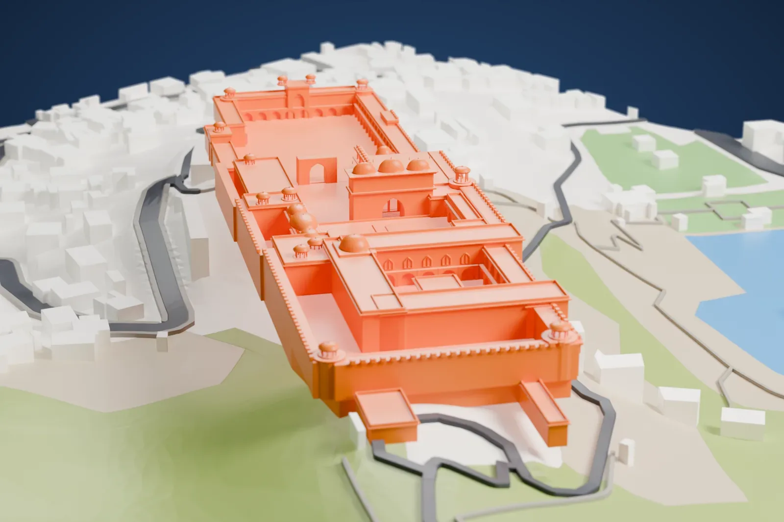 A white 3D print of Amber Fort, a long palace with courtyards and small domes on a hillside, with water, green hills and town buildings around it.