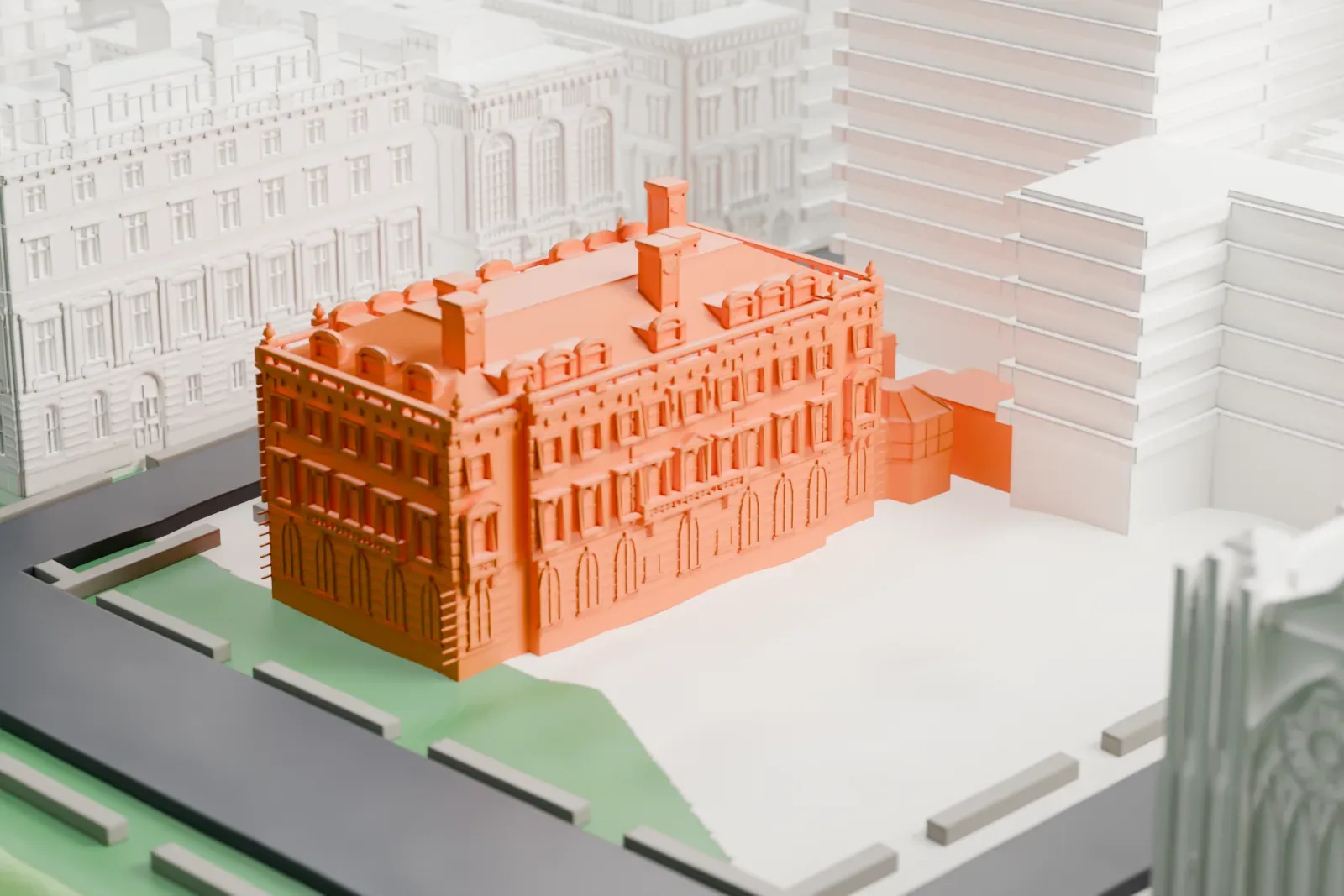 A white 3D print of the Andrew Carnegie Mansion, a brick and stone house with dormers and chimneys beside a street and a garden, near larger buildings.