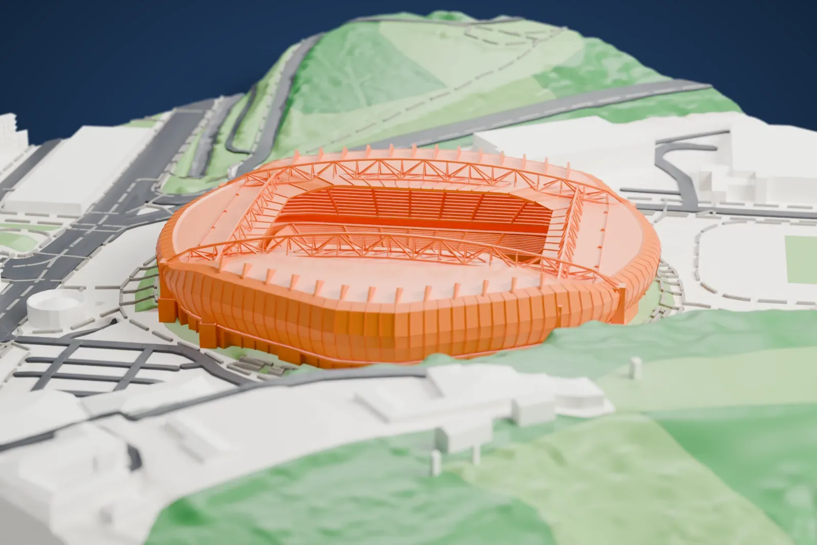 A white 3D print of Anoeta Stadium, an oval stadium with angled roof trusses and a jagged roof edge, standing at the foot of a green hillside beside roads and buildings.