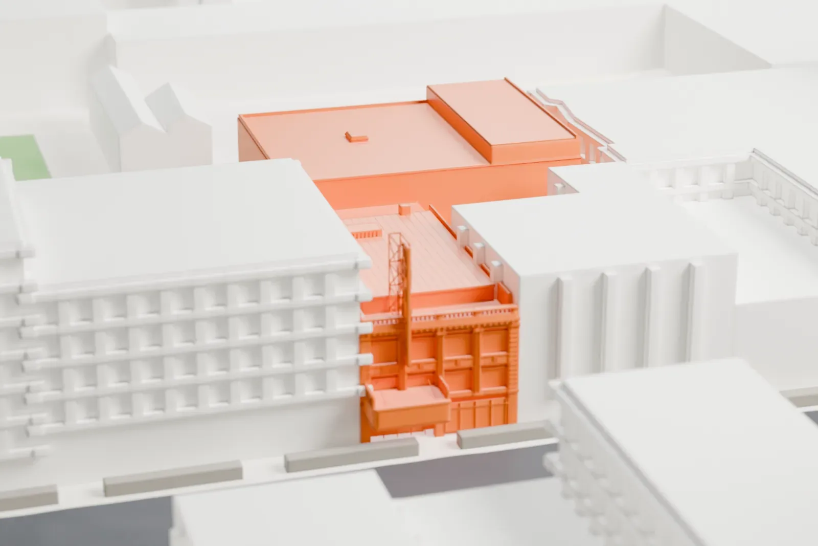 A white 3D print of the Apollo Theater, a plain boxy building with an open lattice-like frame at its front, among low city blocks and streets.