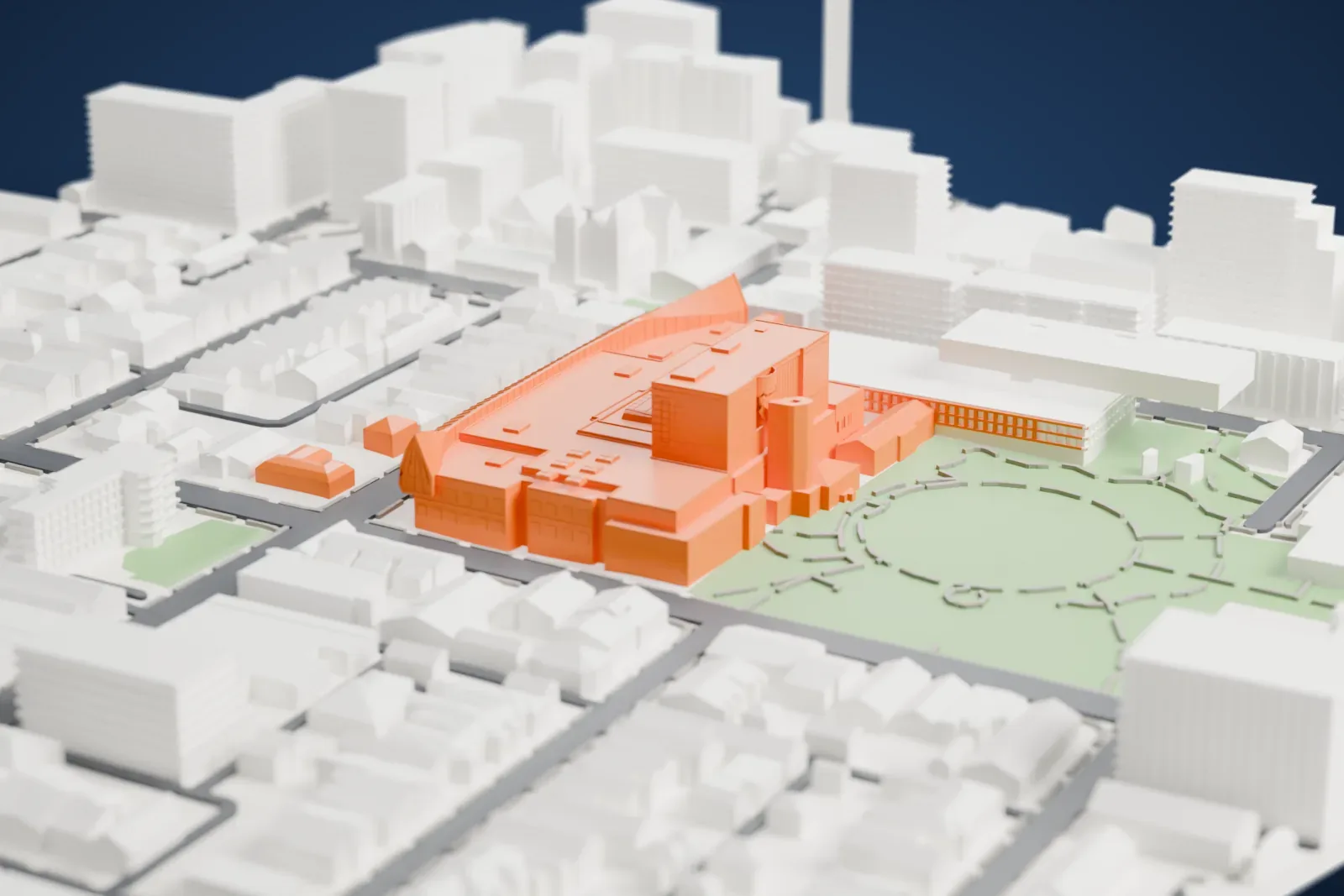 A white 3D print of the Art Gallery of Ontario, a wide group of blocks with a long curved ribbed canopy along one side, beside a park and surrounded by streets and buildings.