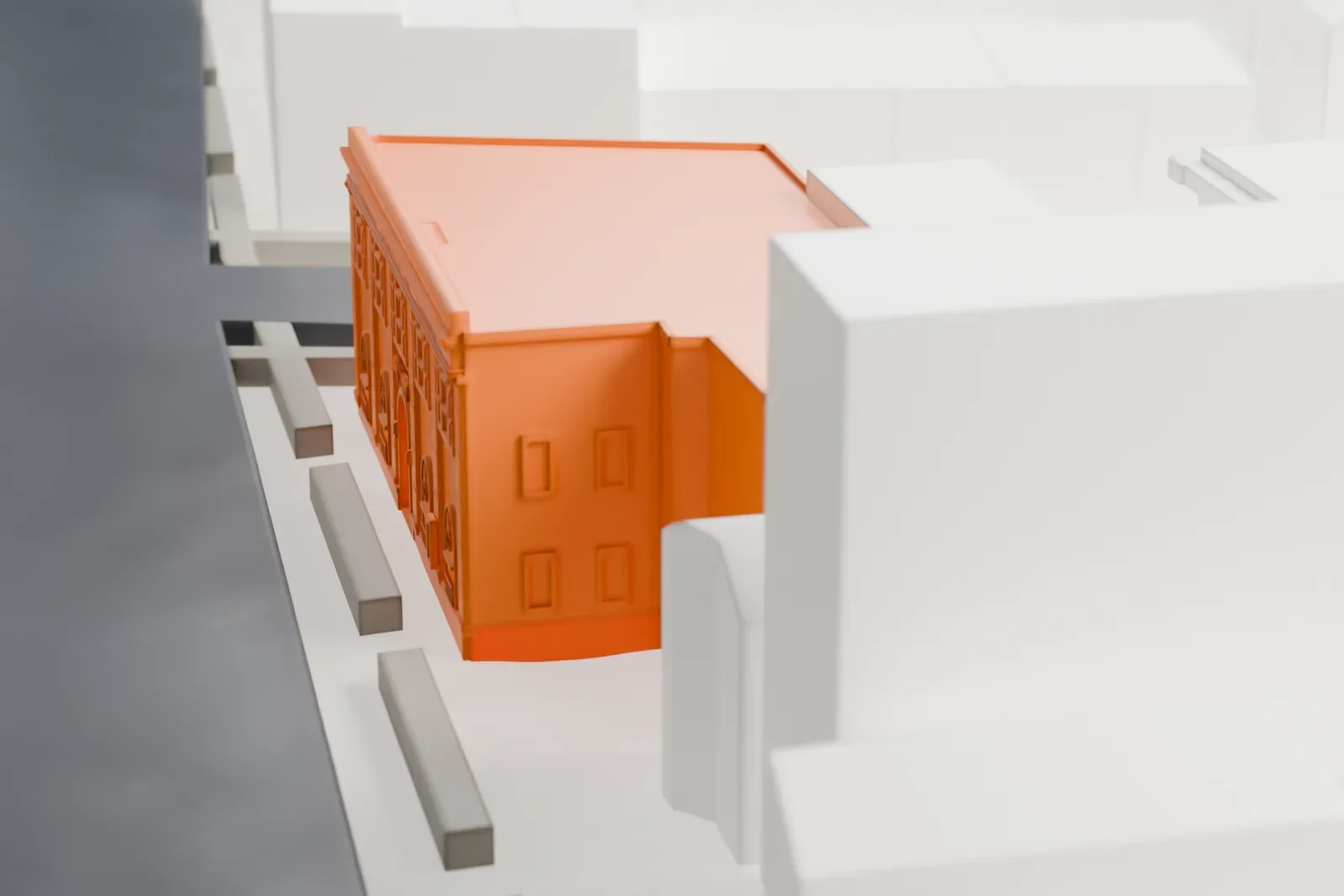 A white 3D print of the Astoria Center of Israel, a two-story building with tall arched windows on its front, surrounded by taller and lower buildings and streets.