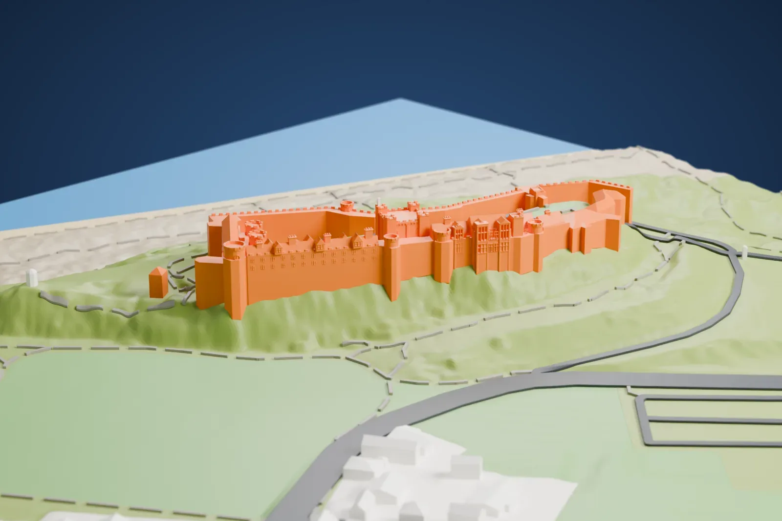 A white 3D print of Bamburgh Castle, a long walled castle on a grassy hilltop above a sandy beach and the sea, with a few houses and roads nearby.