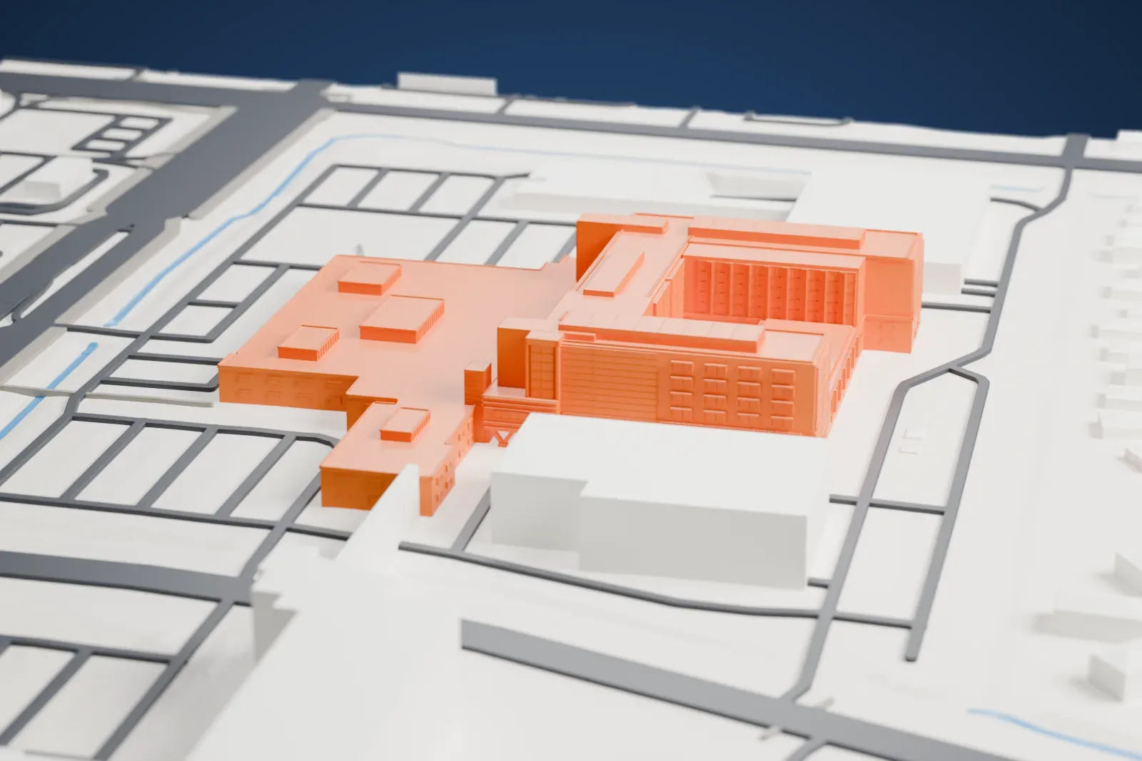A white 3D print of Banner Estrella Medical Center, a low hospital campus with patient wings around an open courtyard, among the surrounding streets and buildings of west Phoenix.