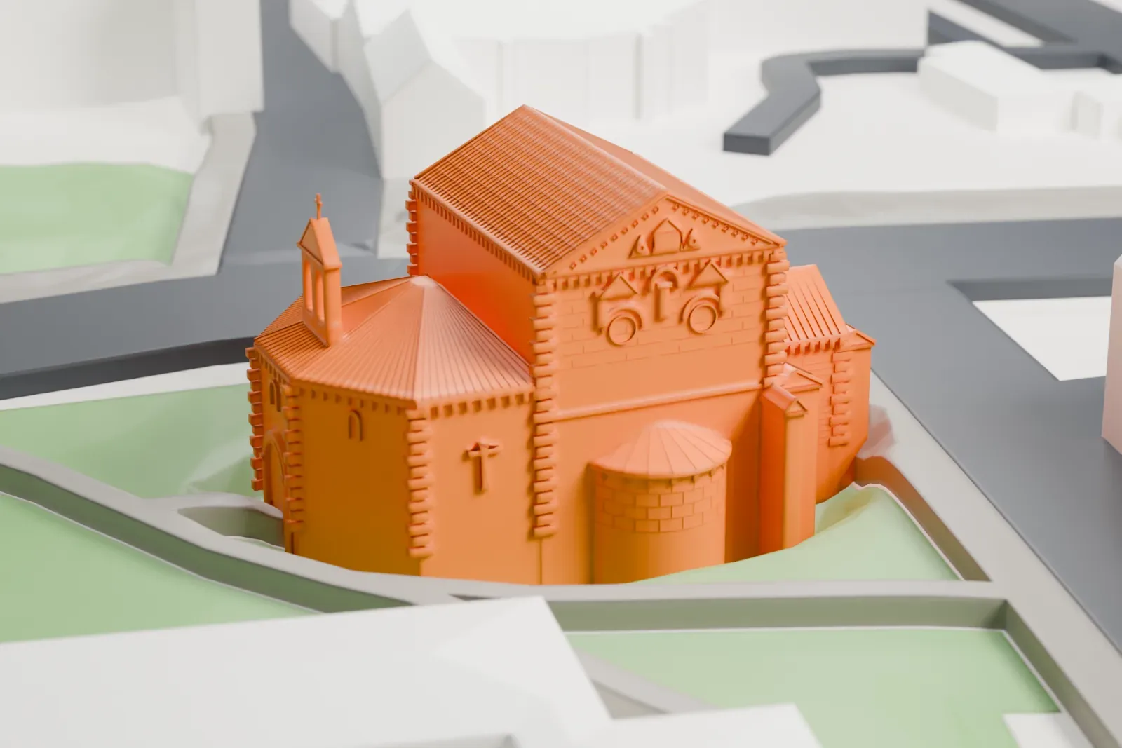 A white 3D print of the Baptistère Saint-Jean, a small church with a pitched roof, a polygonal apse and a small bell gable, among surrounding streets and buildings.