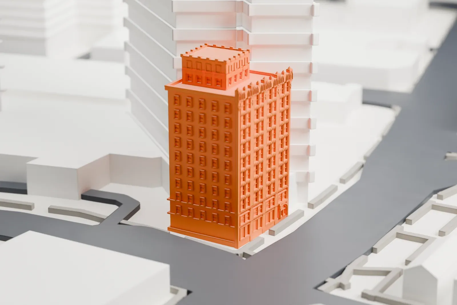 A white 3D print of the Bar Building, a tall block with a crenellated penthouse on top, standing between taller neighboring buildings beside a curving road.