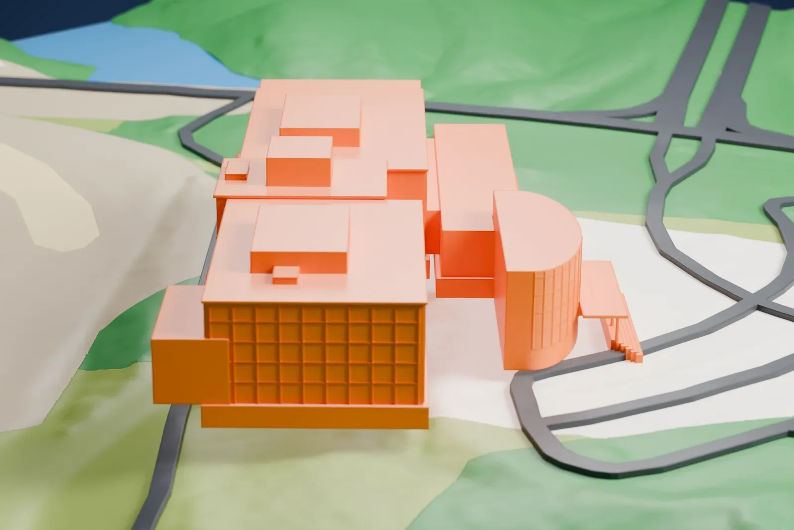 A white 3D print of the Barber Vintage Motorsports Museum, a wide stepped building with a rounded entrance, on a green hillside beside curving roads and a race track.