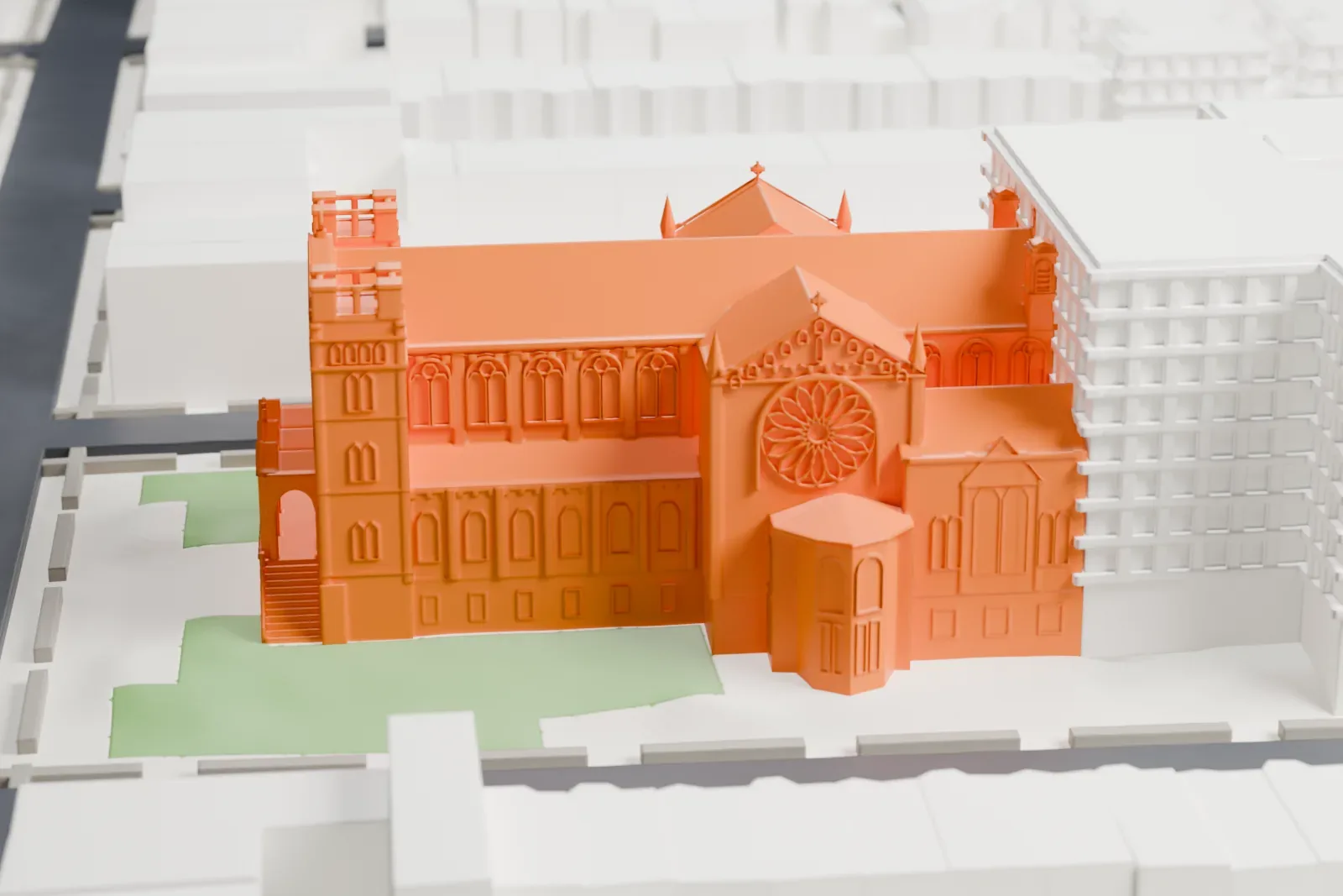A white 3D print of Our Lady of Perpetual Help Basilica, a large church with two crenellated towers, a round window and a long pitched roof, with grassy lawns around it among city blocks.