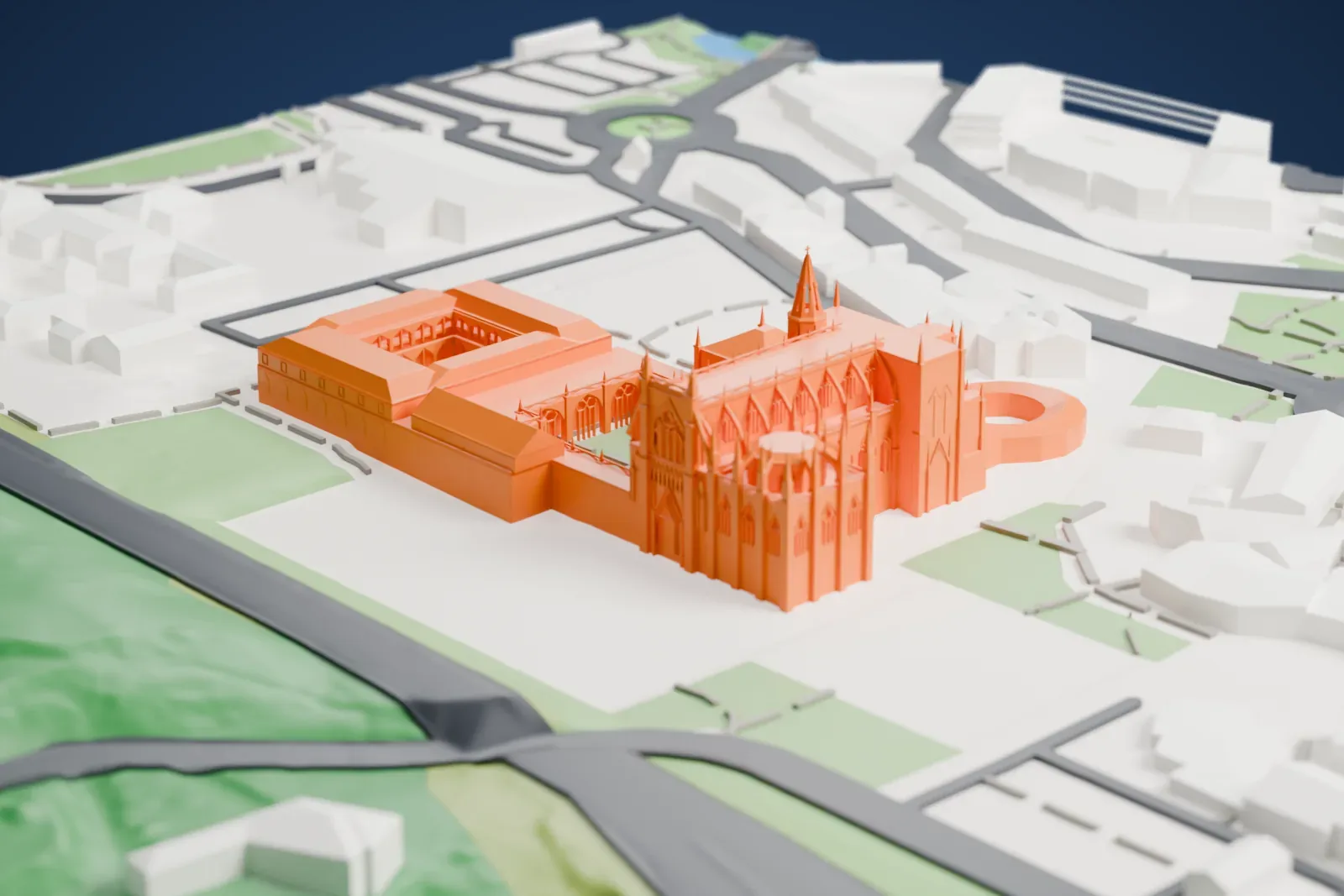 A white 3D print of Batalha Monastery, a pinnacled Gothic church with a cloister and an octagonal chapel, standing on open ground beside streets, buildings and green slopes.