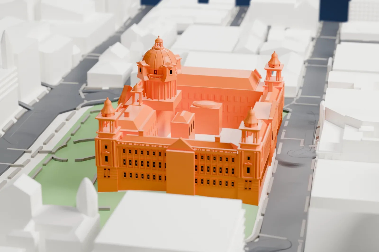 A white 3D print of Belfast City Hall, with its central dome and four corner towers, in green grounds with paths, ringed by streets and buildings.