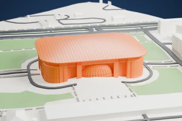 A white 3D print of the Belgrade Arena, a large block with rounded corners and a long ribbed curved roof, with a small ribbed dome at the entrance, set among grass, roads and mid-rise buildings.