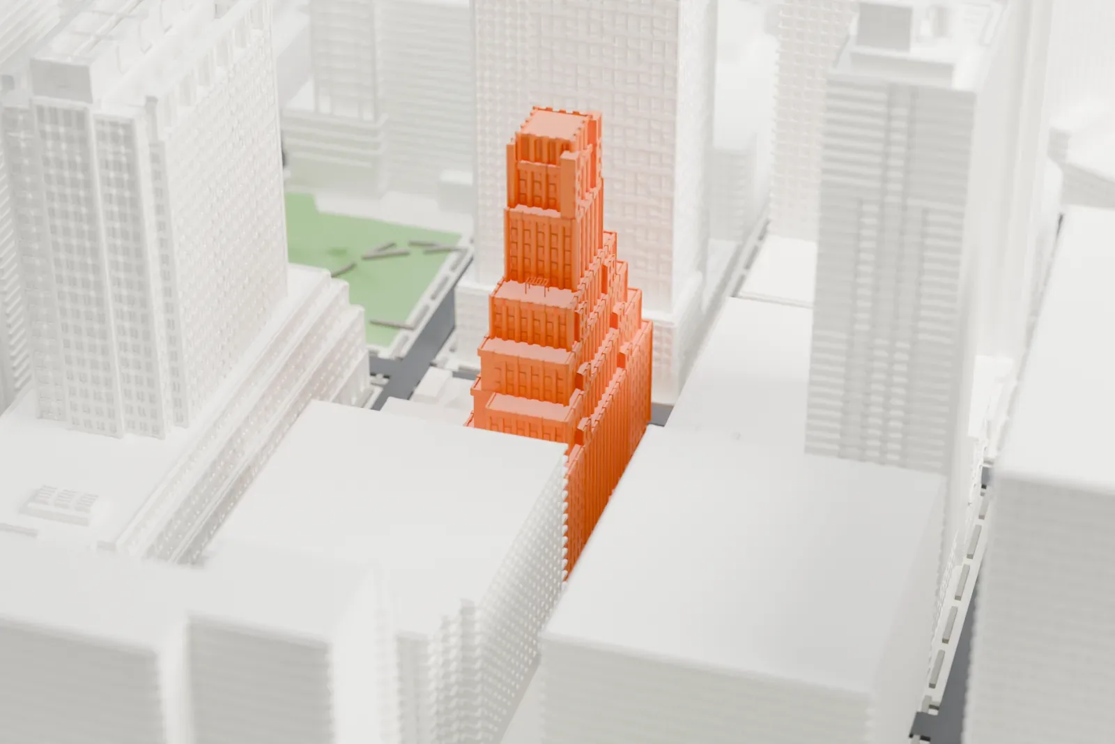 A white 3D print of the BellTel Lofts, a setback tower with a narrow, vertically ribbed crown, standing between much taller buildings.