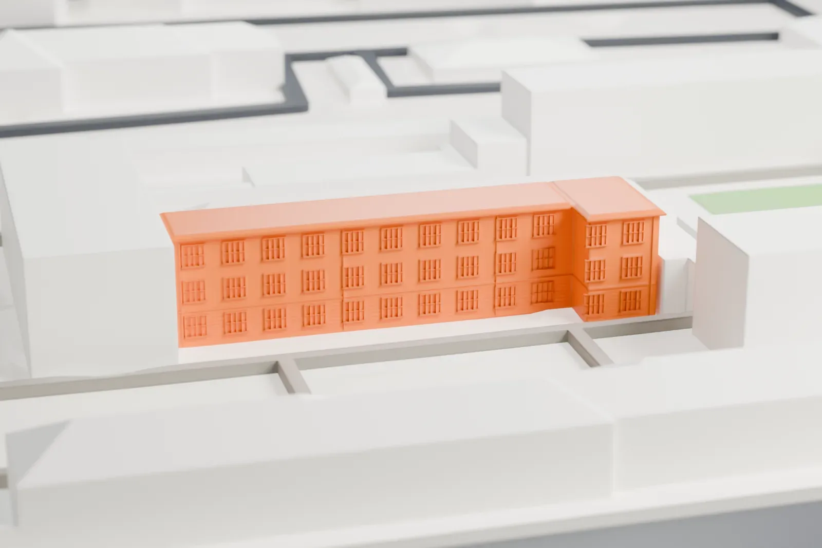 A white 3D print of the Berlin-Hohenschönhausen Memorial, a low prison and museum complex, set among surrounding city buildings and streets.