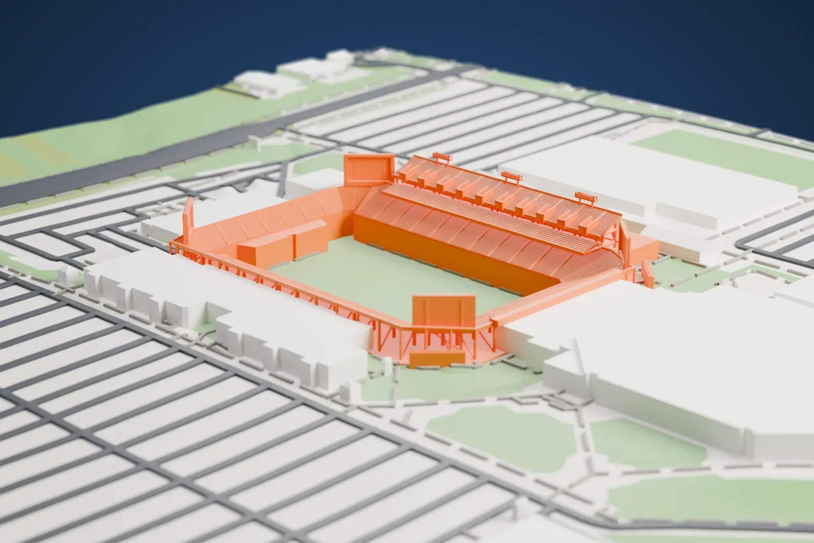 A white 3D print of Bill Snyder Family Stadium, an open football bowl with tiered stands and a green field, surrounded by large buildings, streets and patches of green.