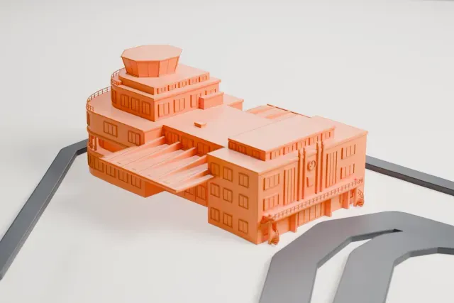 A white 3D print of the Birmingham Airport Elmdon terminal model in Birmingham, with the streets around it.
