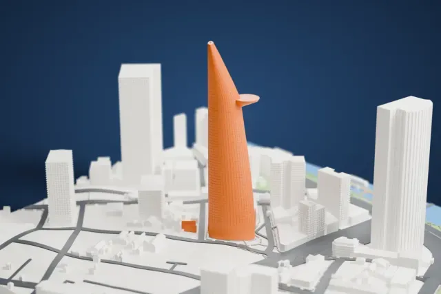 A white 3D print of the Bitexco Financial Tower, a tall tapering tower with a round platform jutting from one side, among high-rise buildings and streets.