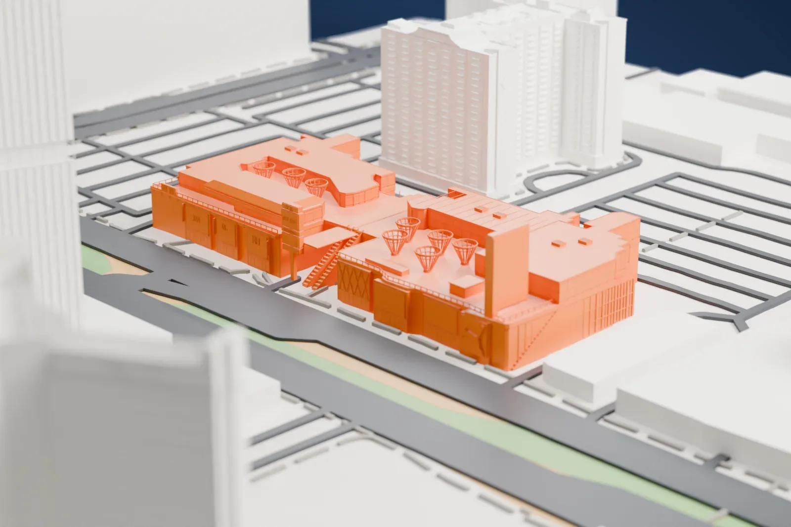 A white 3D print of the BLVD Las Vegas shopping center with a broad roof and flared lattice features, beside wide streets and taller surrounding buildings.