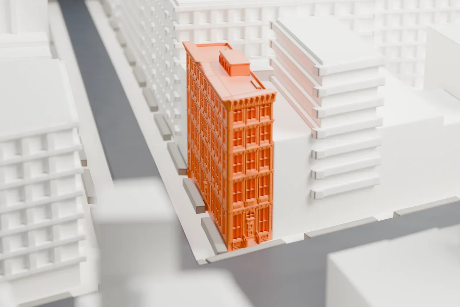 A white 3D print of the Bouwerie Lane Theatre, a narrow building with a facade packed with windows and a cornice at the roofline, standing between larger buildings beside a street.