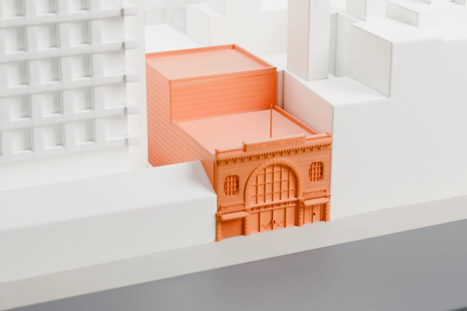 A white 3D print of the Bowery Ballroom, a small low building within tightly packed city blocks, with parks and streets nearby.