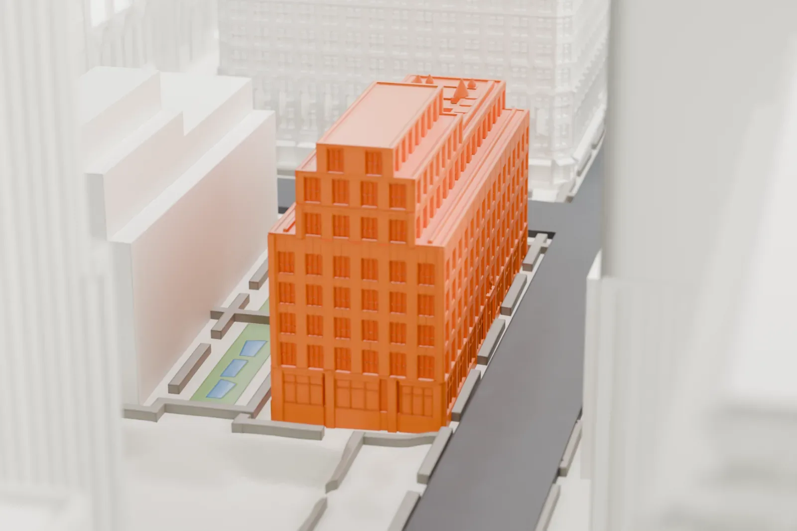 A white 3D print of the British Empire Building, a stepped, six-story block with small rooftop details, squeezed between taller towers.