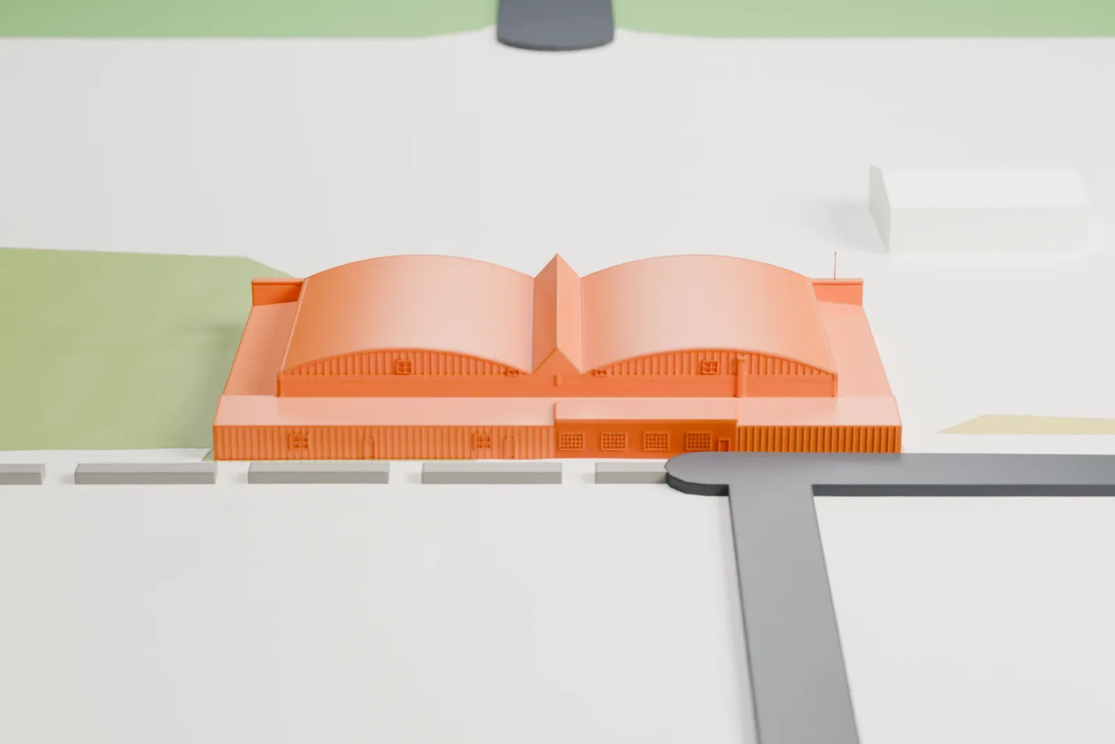 A white 3D print of Building 29, a wide aircraft hangar with two arched roofs and low wings along its sides, standing on an open airfield with a few small buildings nearby.