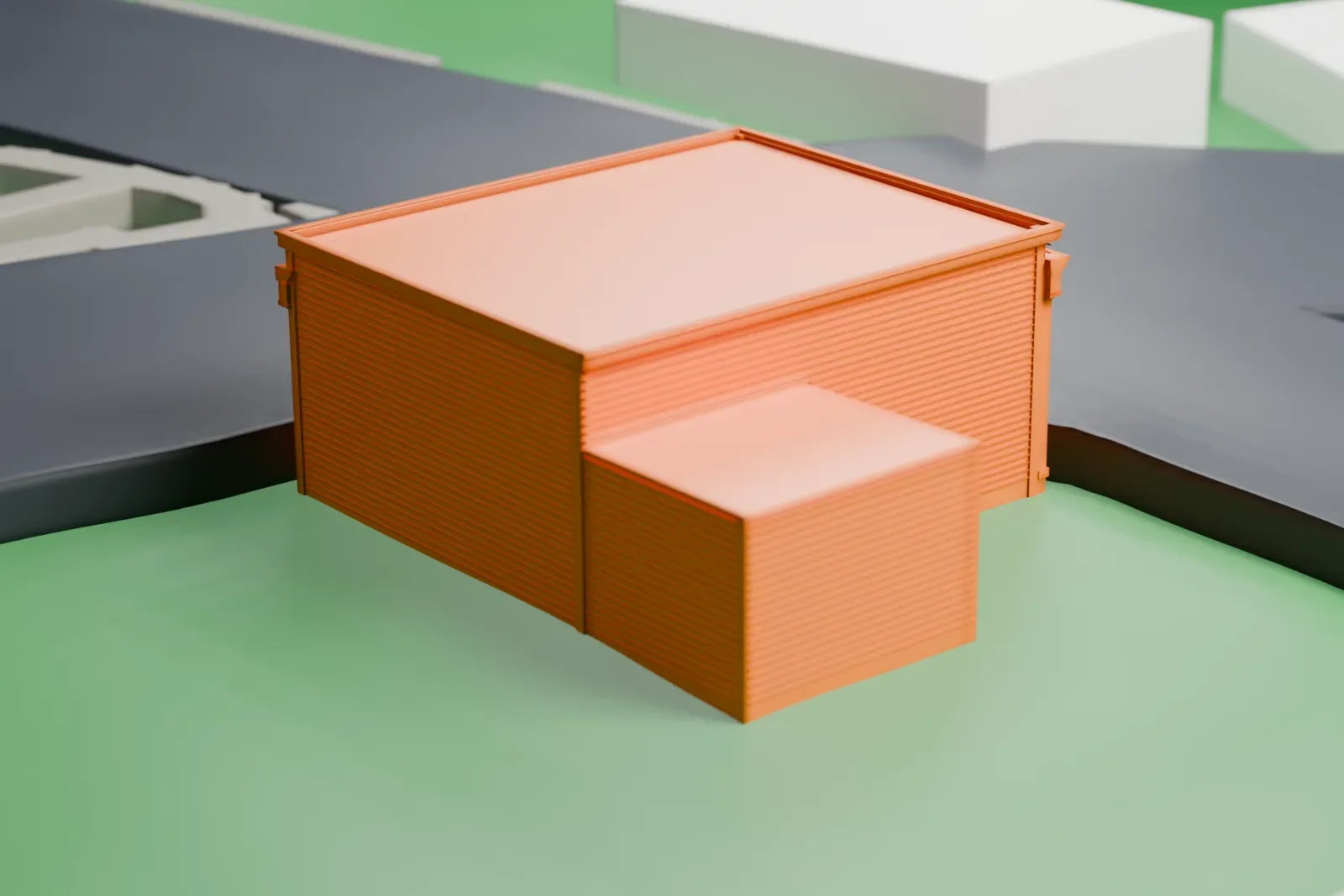 A white 3D print of the Burton Store, a one-story flat-roofed building with a smaller wing beside it, on a green lot between streets.