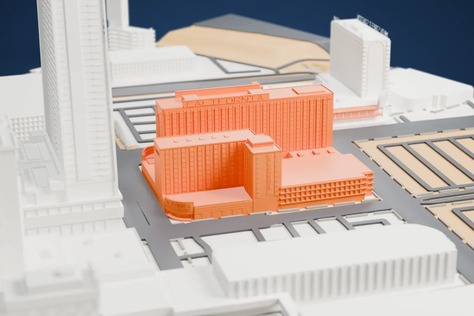 A white 3D print of the California Hotel and Casino, two adjoining hotel towers with lettering along the roofline, among downtown buildings, streets and parking lots.