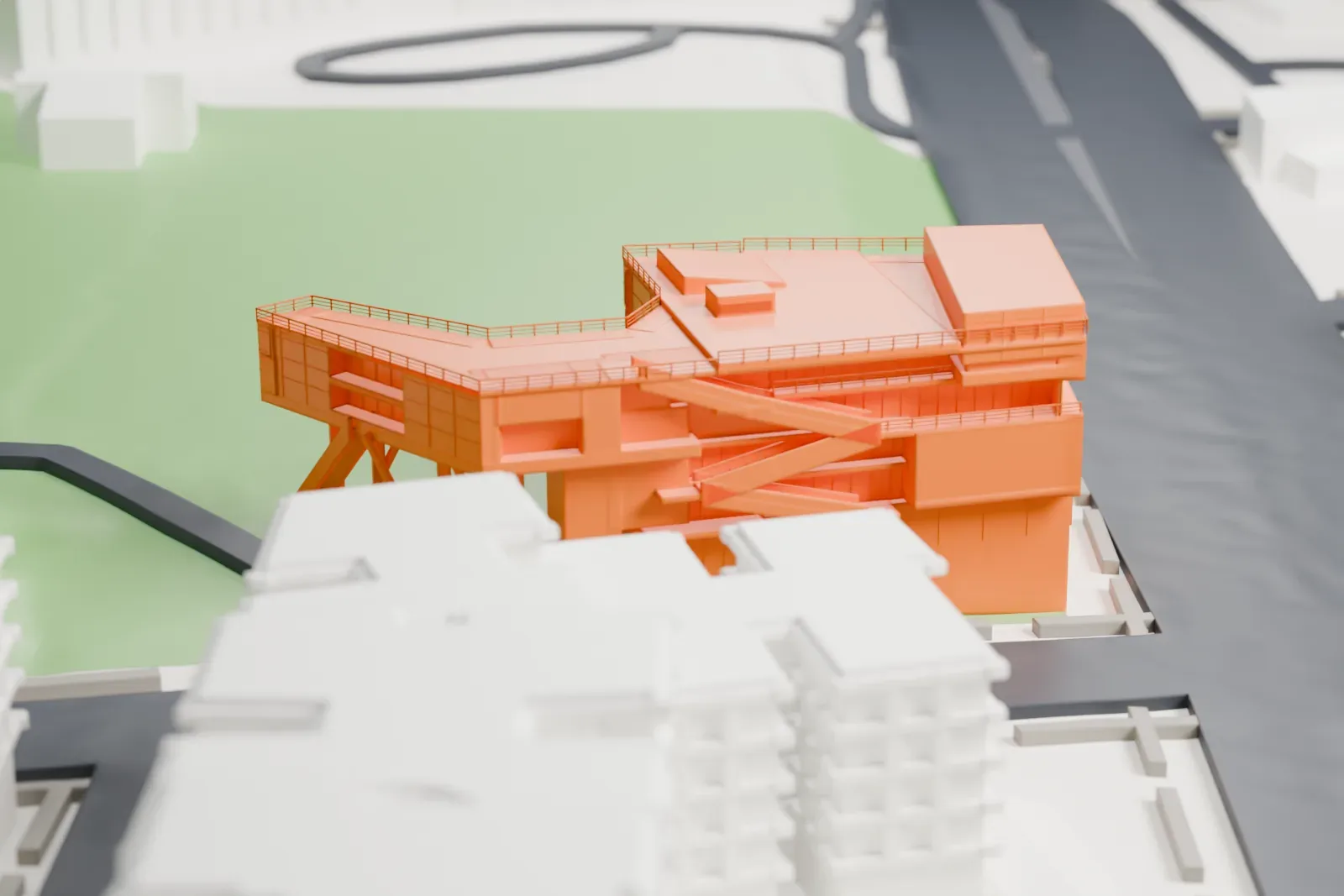A white 3D print of the Campbell Sports Center, a boxy building with angled supports and a long walkway, standing on open grounds beside a street.