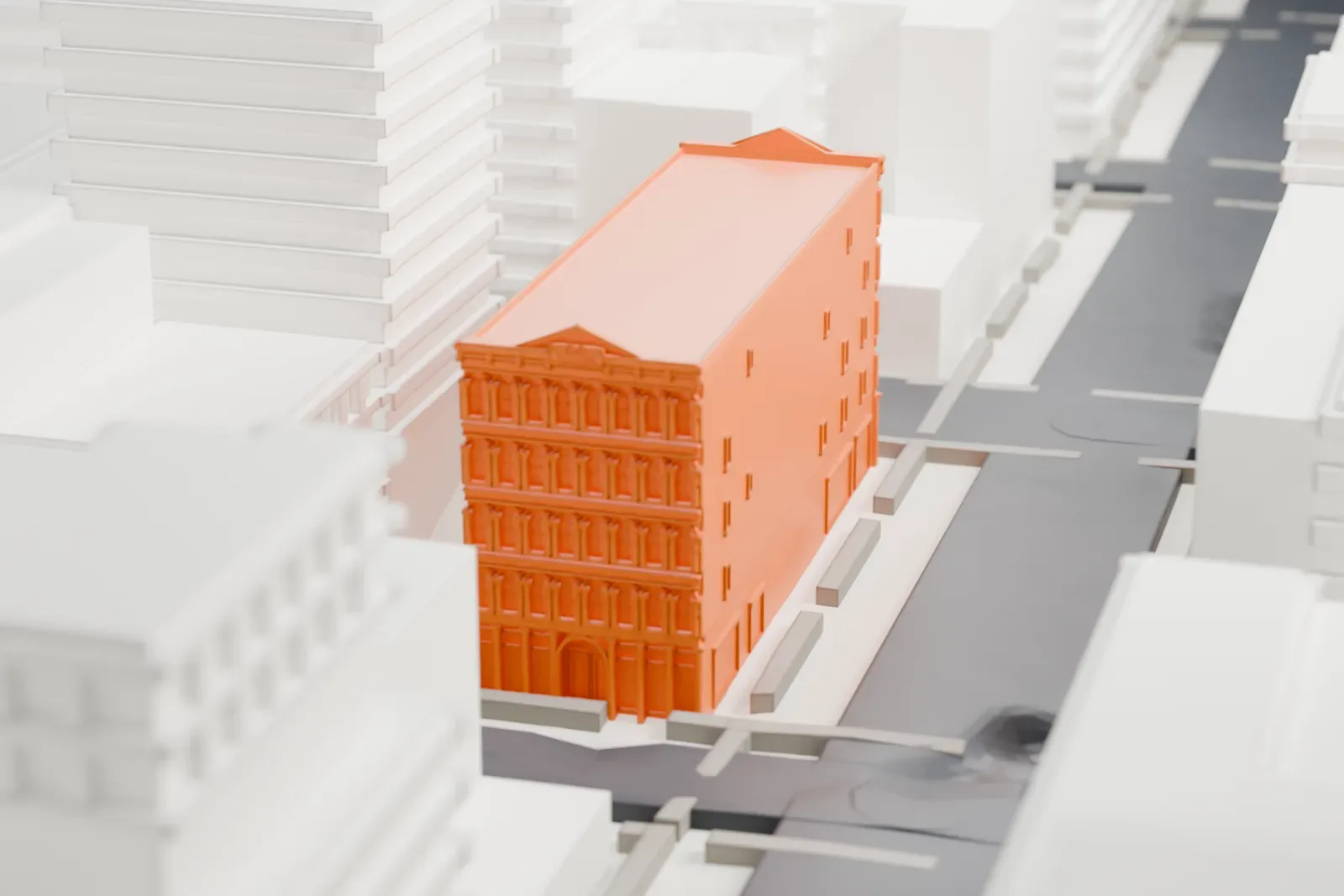 A white 3D print of the Cary Building, a long narrow block with an ornate gabled facade at one end, between taller neighboring buildings.