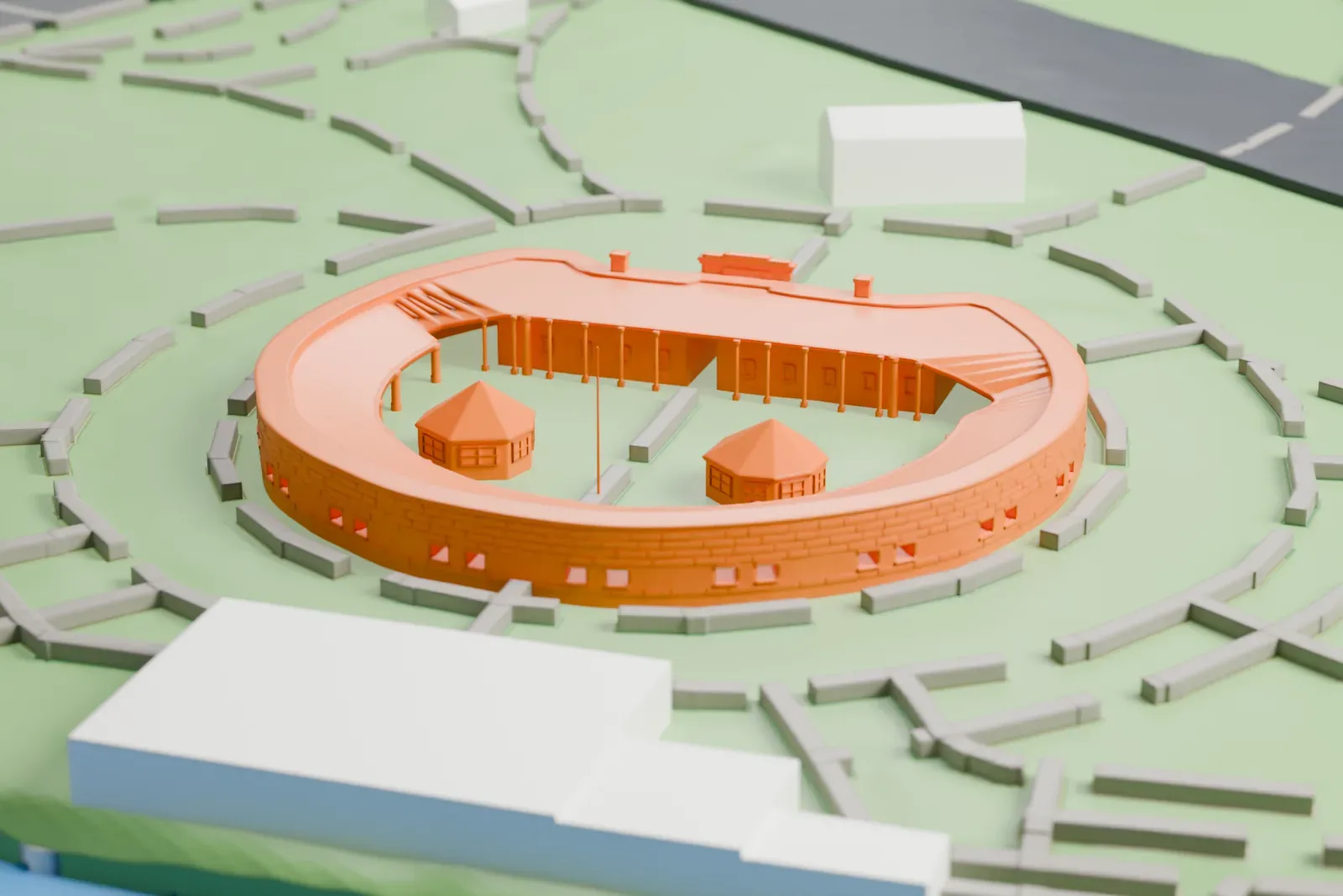 A white 3D print of Castle Clinton, a low circular fort with two small pavilions in its yard, set on a lawn with park paths and water beyond.